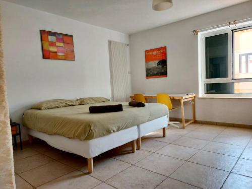 a bedroom with a bed and a table and chairs at Benedetto Cairoli Guest House in Bari