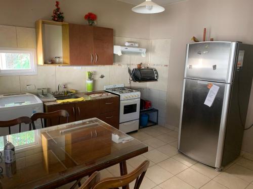 a kitchen with a stainless steel refrigerator and a table at Rivadavia San Juan casa en alquiler cotización oficial in San Juan