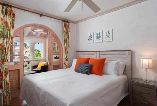 a bedroom with a large bed with orange pillows at Paradise Palms Sugar Hill in Saint James