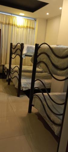 three bunk beds in a room with a window at Hotel Dubai in Manizales