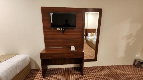 a hotel room with a television and a mirror at فندق أبراج المسك Abraj Almisk Hotel in Makkah