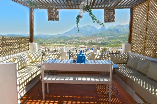 una mesa y un banco en un balcón con vistas en Riad Darna, en Tetuán