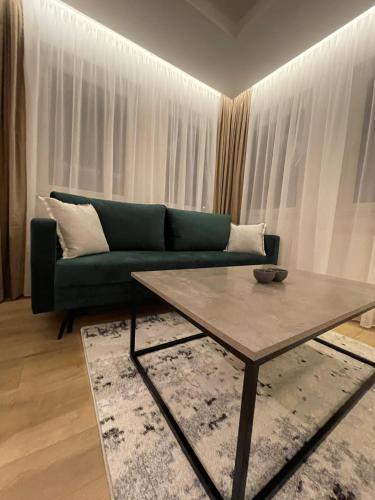 a living room with a green couch and a coffee table at Apartments Stećak in Sarajevo