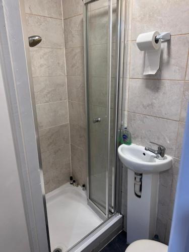 La salle de bains est pourvue d'une douche et d'un lavabo. dans l'établissement HEART OF HANGER LANE, à Londres