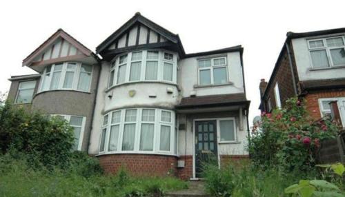 a house with a cat face on the front of it at HEART OF HANGER LANE in London