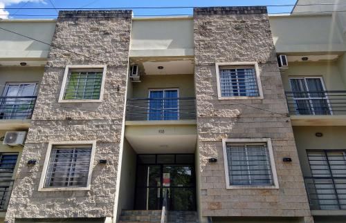 un edificio de piedra con ventanas y una puerta en Departamento 5 en Puerto Iguazú