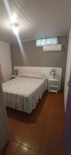 a bedroom with a white bed and a window at El Remanso in Durazno