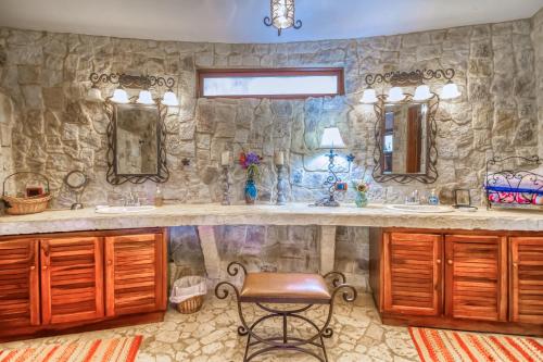 Baño de piedra con 2 lavabos y silla en Villa Cielo, en Atenas
