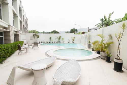 a patio with a pool and chairs and a table at LeBlanc Hotel in Antipolo
