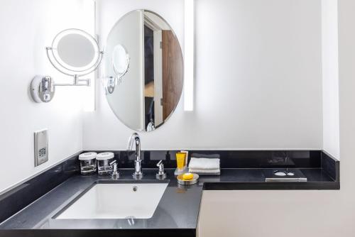 a bathroom with a sink and a mirror at Sandman Signature Aberdeen Hotel & Spa in Aberdeen