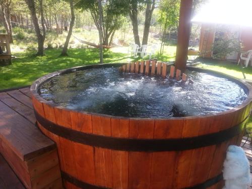 a barrel hot tub with water in a yard at Cabañas Maroni in Las Trancas