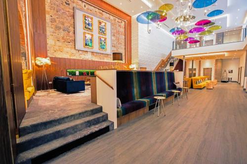 a lobby with stairs and chairs and a bar at Sandman Signature Aberdeen Hotel & Spa in Aberdeen