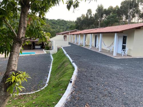 a house with a gravel driveway next to a building at Pousada Saint James in Águas de Lindóia