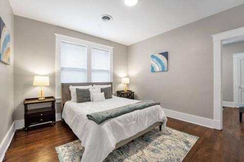 a bedroom with a large bed and two lamps at Contemporary Cottage near zoo and Rhodes college in Memphis