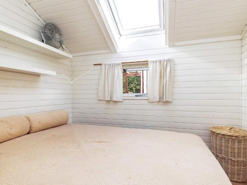 um pequeno quarto com uma cama e uma janela em Holiday home Præstø V em Praesto