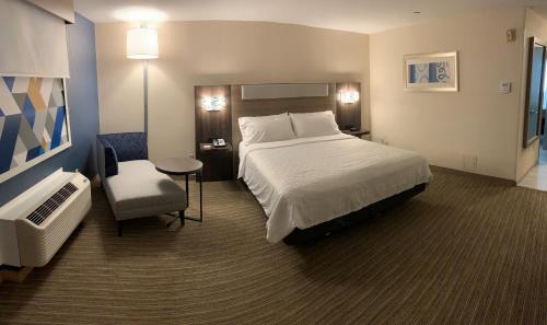 a hotel room with a bed and a chair at Holiday Inn Express Hotel & Suites Hermosa Beach by IHG in Hermosa Beach
