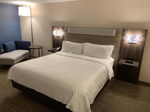 a hotel room with a large bed and a chair at Holiday Inn Express Hotel & Suites Hermosa Beach by IHG in Hermosa Beach