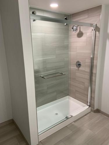 a shower with a glass door in a bathroom at Holiday Inn Express Hotel & Suites Hermosa Beach, an IHG Hotel in Hermosa Beach