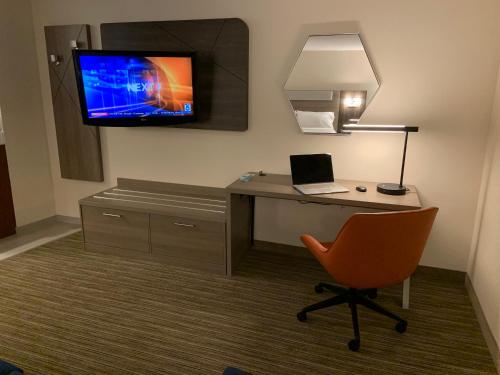 a room with a desk with a laptop and a tv at Holiday Inn Express Hotel & Suites Hermosa Beach by IHG in Hermosa Beach