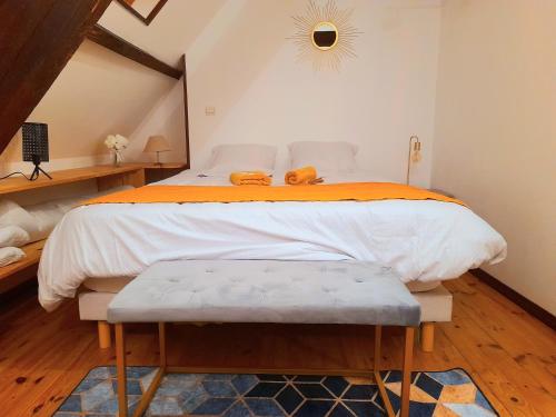 - une chambre avec un grand lit et une couverture orange dans l'établissement Le Nid d'hirondelles - Appartement de caractère hypercentre au calme, à Bourges