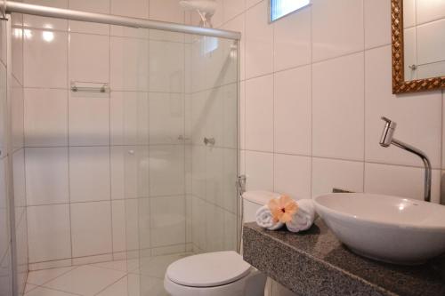 a bathroom with a shower and a toilet and a sink at Pousada Vila Palma Boipeba in Ilha de Boipeba