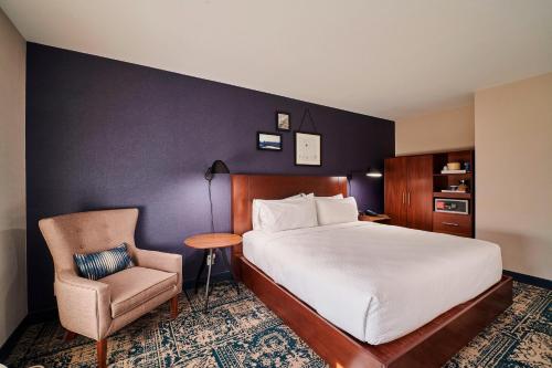 a hotel room with a bed and a chair at Four Points by Sheraton Cleveland-Eastlake in Eastlake