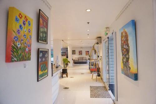 un pasillo con pinturas en las paredes de una casa en LeBlanc Hotel en Antipolo