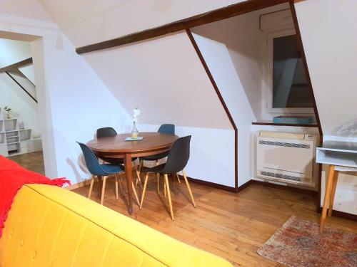 - une salle à manger avec une table et des chaises dans l'établissement Le Nid d'hirondelles - Appartement de caractère hypercentre au calme, à Bourges