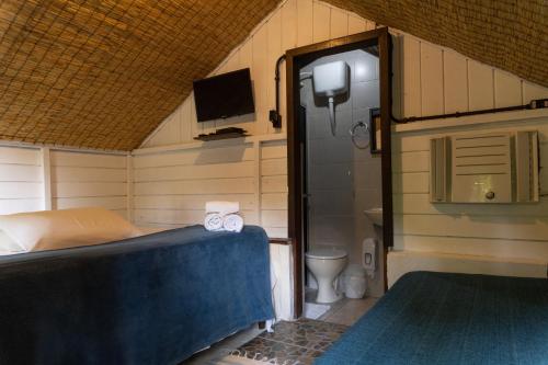 a small room with a bed and a toilet at Pousada Orquideas in Ilha do Mel