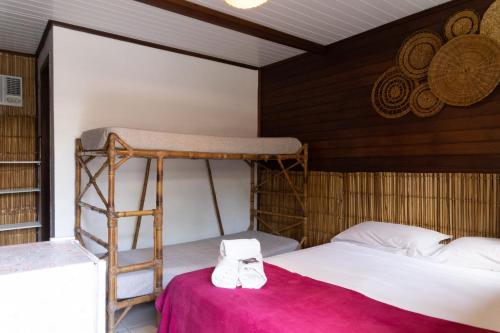 a bedroom with a bunk bed and a red table at Pousada Orquideas in Ilha do Mel