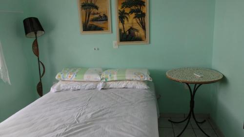 a bedroom with a bed and a table with a lamp at Casa do Gaspar in São Francisco do Sul