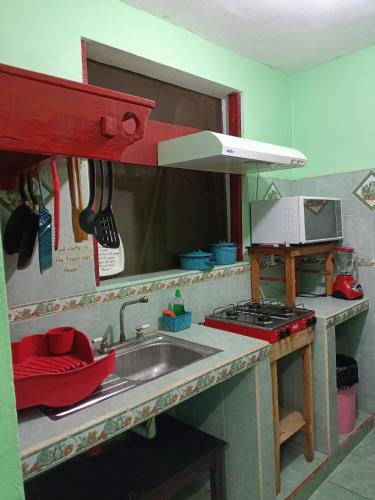 a kitchen with a sink and a stove at Casa Bonzay in Bacalar
