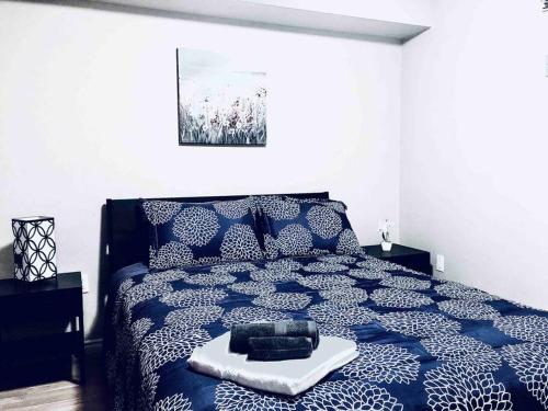 a bedroom with a blue and white bed with a tray on it at 2 BDRM A/C Condo w/Ensuite Laundry + Free Parking in Edmonton