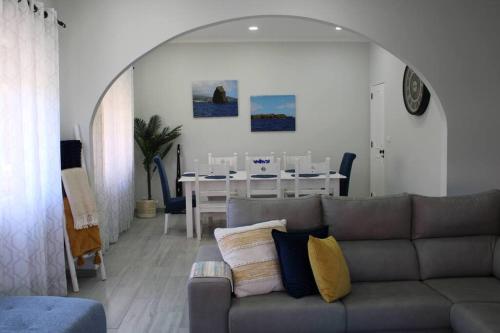 a living room with a couch and a dining room at Casa das Palmeiras - Res. of Elizabete and Fatima in Horta