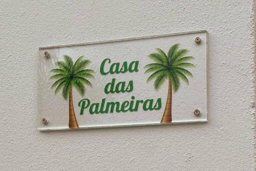 a sign with two palm trees on a wall at Casa das Palmeiras - Res. of Elizabete and Fatima in Horta