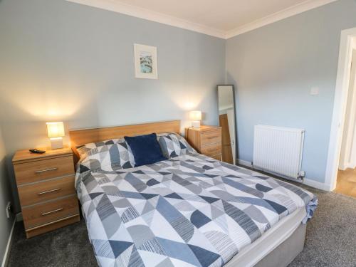a bedroom with a bed and a dresser and two lamps at Rothiemay in Girvan