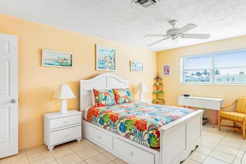 a bedroom with a bed and a ceiling fan at Ninth Street Getaway in Key Colony Beach