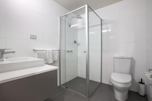 a bathroom with a toilet and a glass shower at Nightelier Doncaster in Doncaster