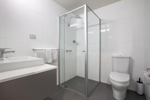 a bathroom with a toilet and a glass shower at Doncaster Apartments by Nightcap Plus in Doncaster