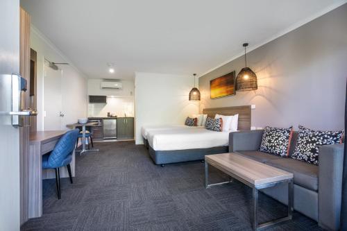 a hotel room with a bed and a couch at Doncaster Apartments by Nightcap Plus in Doncaster