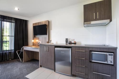 a kitchen with a sink and a microwave at Nightelier Doncaster in Doncaster