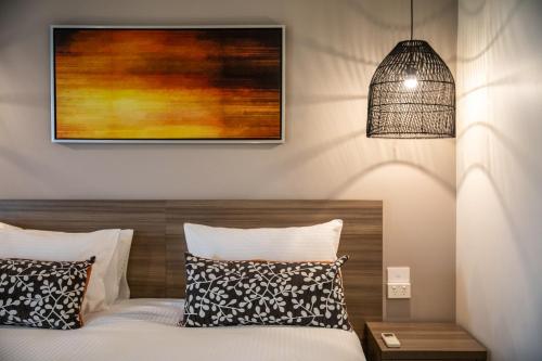 a bedroom with a bed and a pendant light at Nightelier Doncaster in Doncaster