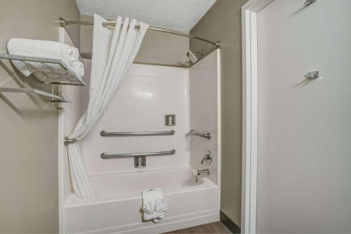y baño con bañera y cortina de ducha. en Motel 6-Pharr, TX en Pharr