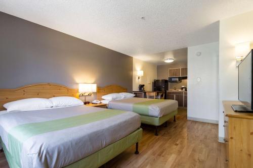 um quarto de hotel com duas camas e uma cozinha em Studio 6-Tempe, AZ em Tempe