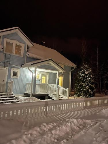 a house with a porch in the snow at night at Pan Golf & Spa Villas in Imatra