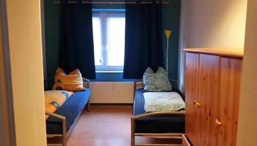 um pequeno quarto com 2 camas e uma janela em worker-flat em Gelsenkirchen