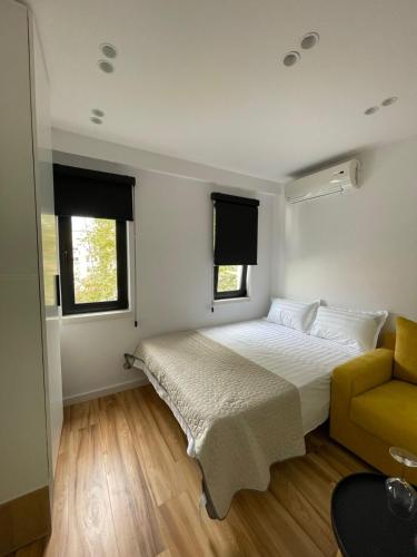una camera con un letto e un divano giallo di Digital Nomad Central ap a Tirana