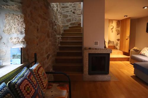 sala de estar con escalera y chimenea en Casa do Soito., 