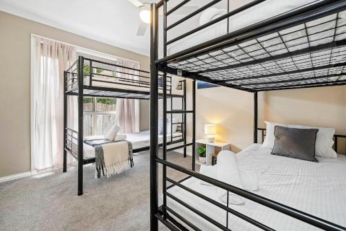a bedroom with two bunk beds and a chair at Skip, Shop, Splash in Rye