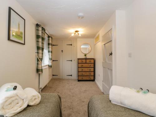 a room with two beds and a dresser in a room at Thomas Cottage in Wotton-under-Edge